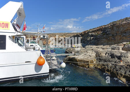 Excursion boats moored stern-to the rocks, Mediterranean-style, to allow tourists to go ashore in Blue Lagoon, Camino Stock Photo
