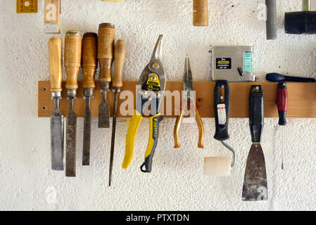 Woodworking Tools & Hand Tools including Chisels and Pliers Hanging in Workshop or Garage Wall-Mounted Tool Rack Stock Photo