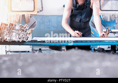 Production of PVC windows, the worker records dimensions on the profile of the frame pvc, felt pen arm Stock Photo