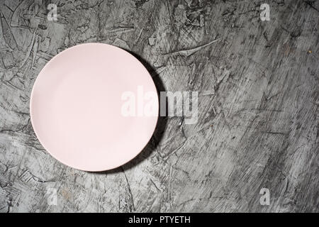 Empty pink plate on concrete background with copy space. Flat lay.. Stock Photo