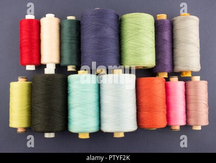 multi-colored skeins of threads on a blue background Stock Photo