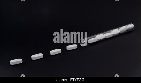 Pills in a test tube on a black background Stock Photo