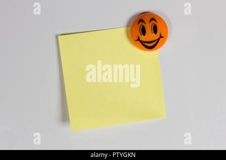 Yellow empty sticker on the fridge with a cheerful smile Stock Photo