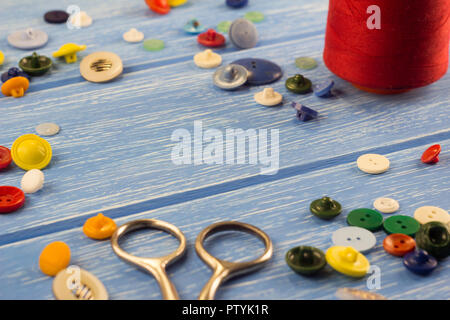scissors, buttons and threads on a wooden background Stock Photo