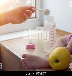 Mother prepares milk for her child, an Apple, close-up Stock Photo