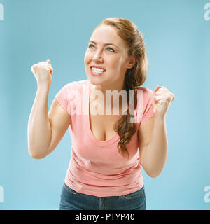 I won. Winning success happy woman celebrating being a winner. Dynamic image of caucasian female model on blue studio background. Victory, delight concept. Human facial emotions concept. Trendy colors Stock Photo
