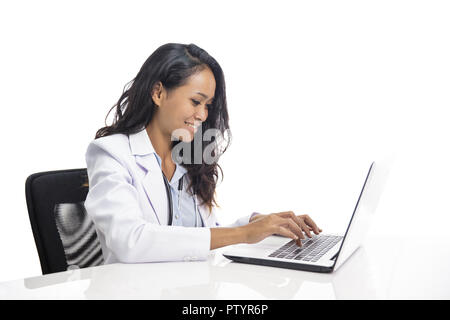 asian young doctor  smiling and working on her laptop Stock Photo