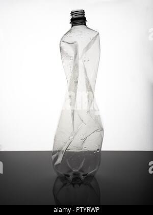 A large, empty, crumpled plastic soda bottle against a white background Stock Photo