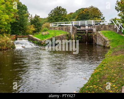 Hirst Lock and spillway on the Leeds and Liverpool Canal in early autumn near Saltaire West Yorkshire England