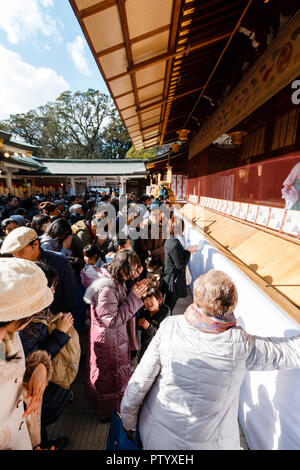 Japanese new year, shogatsu. People standing and praying at the scared area in the main hall, Honden of the Nishinomiya Shinto shrine. Stock Photo