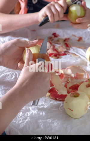 vertical image of a mother and daughter peeling apples for cooking blurred background to ad copy space Stock Photo