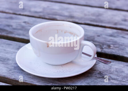 A used empty coffee cup and saucer on a wooden table, closeup, United Kingdom Stock Photo