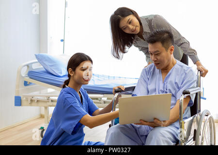 Physical therapist explain treatment method to senior patient and relative using notebook Stock Photo