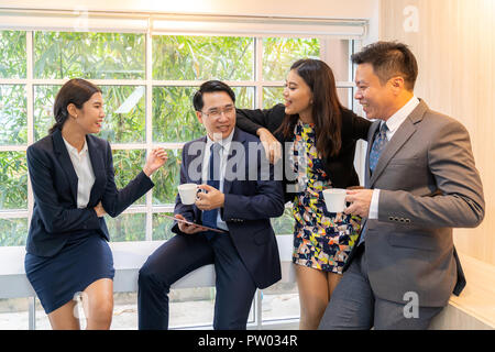 Business people having a conversation near the window in the cafe on coffee time Stock Photo