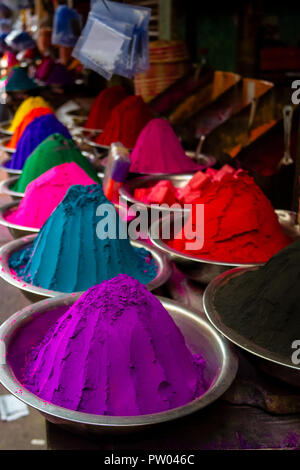 Piles of coloured powder for the Holi festival of colour on display in stainless silver bowls on display for sale on a market stall in India. Stock Photo
