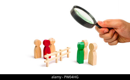 Magnifying glass is looking at the wooden fence divides the two groups discussing the case. Termination and breakdown of relations, breaking ties. Con Stock Photo