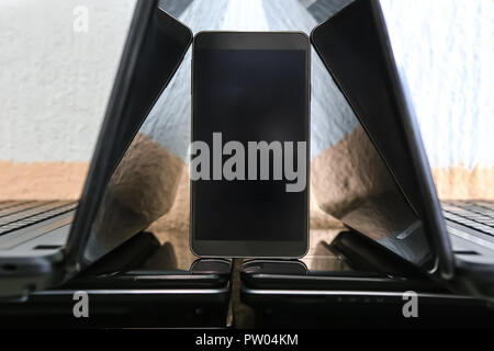 laptops with open monitors and a mobile telephone. Closeup. Stock Photo