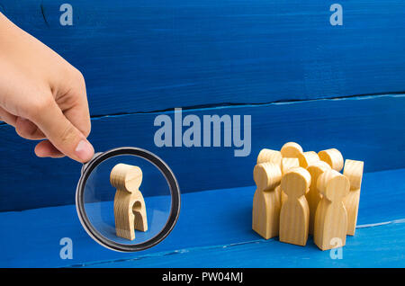 Magnifying glass is looking at A crowd of people stands and looks at the figure of a woman with an emptiness in the form of a child in her body. conce Stock Photo