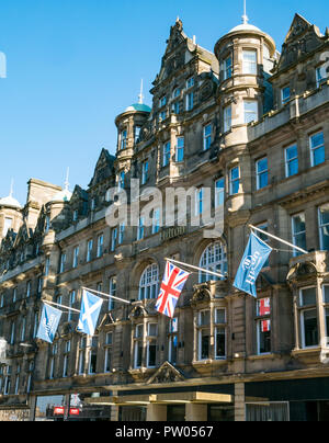 Large Scottish baronial style mansion building now Hilton Carlton Hotel, North Bridge, Edinburgh, Scotland, UK with flags Stock Photo