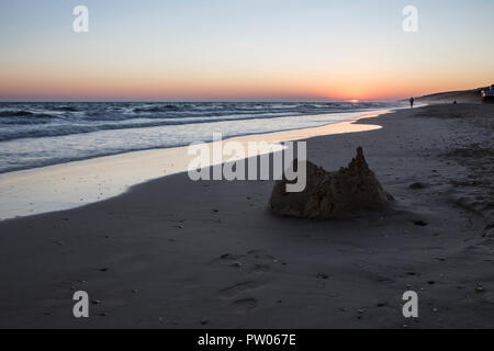 Collapsed sand castle at Matalascañas beach during the magnificent sunrise. Costa de la Luz, Spain Stock Photo