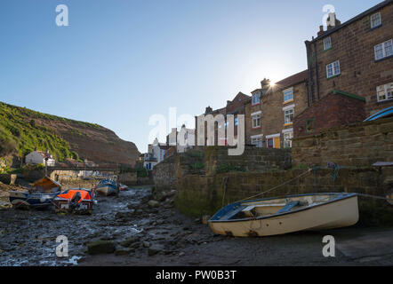 Boats moored in the beck at low tide, Staithes, North Yorkshire, England. A beautiful historic fishing village, popular with tourists. Stock Photo