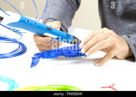 Kid's hands creating with 3d printing pen Stock Photo - Alamy