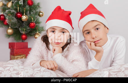 children posing with santa hat in studio Stock Photo