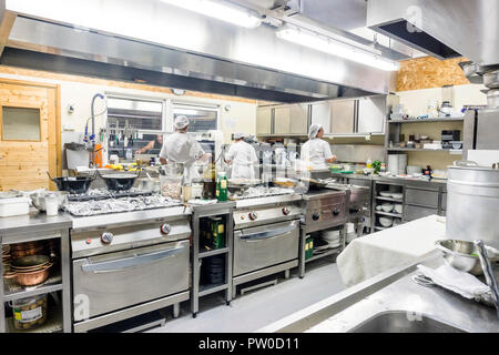 Kitchen staff busy with preparing food during lunch time in the restaurant Stock Photo