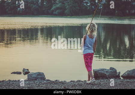 Adorable Little Girl Fishing with Fishing Rod at the Pond at the