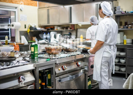 Kitchen staff busy with preparing food during lunch time in the restaurant Stock Photo
