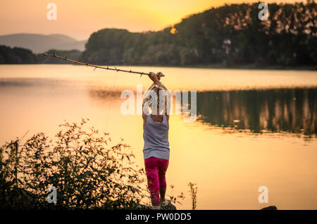 Adorable Little Girl Fishing with Fishing Rod at the Pond at the