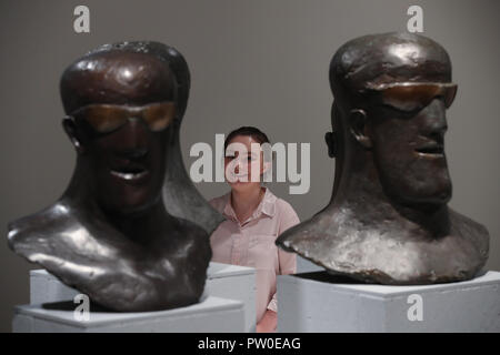 A visitor looks at the Goggle Heads on display at the Elisabeth Frink Humans and Other Animals exhibition preview at the Sainsbury Centre for Visual Arts in Norwich, Norfolk. PRESS ASSOCIATION Photo. Picture date: Thursday October 11, 2018. The exhibition will provide new perspectives and examine her radical and bohemian beginnings in 1950s London, reappraising one of the most important British sculptors of the twentieth century. Photo credit should read: Chris Radburn/PA Wire Stock Photo