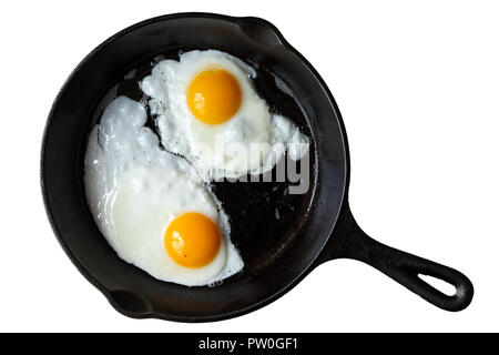 Two fried eggs in cast iron frying pan isolated on white from above. Stock Photo
