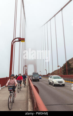 Bikers and traffic on the Golden Gate Bridge San Francisco, California, United States, on a late foggy summer morning. Stock Photo