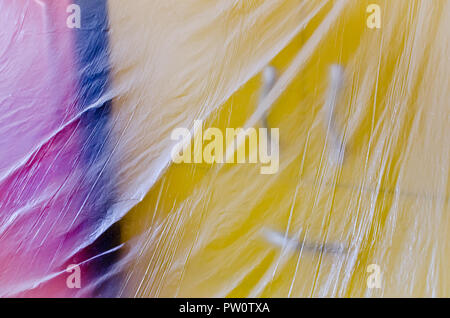detail of red yellow furniture covered with transparent plastic foil, protection from dust and paint while decorating apartment Stock Photo