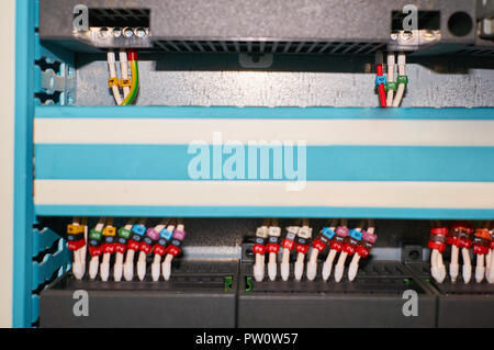 Black controller with connected colored numbered wires. Industrial background. Stock Photo