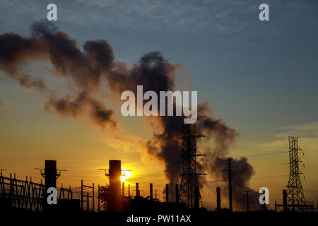 the sun rises over the coal power station on a bitterly cold morning. Stock Photo