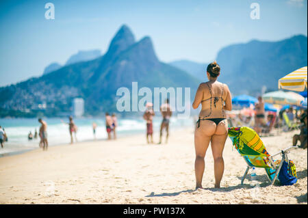 Scenic view of Ipanema Beach on a bright summer afternoon under a looming silhouette of Two Brothers Mountain in Rio de Janeiro, Brazil Stock Photo