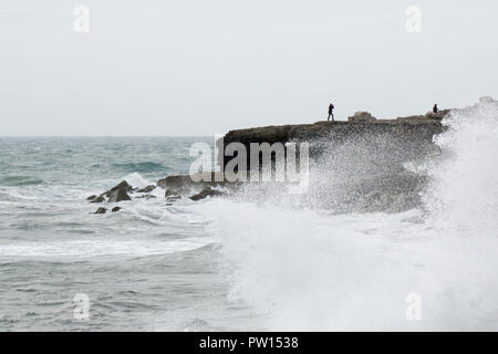 Portland Bill, Dorset, UK. 11th October, 2018. The first major storm of the autumn arrives in south Dorset on the world famous Jurassic coastline at Portland Bill. The exposed peninsular of land feels the early stages of storm Callum as onlookers brave the extreme conditions, strong gales, high waves and sea spray. The first stages of the storm starts to move across the country on Thursday through to the weekend, bringing winds in excess of 60mph rain and potential damage to property in exposed areas. Credit: Wayne Farrell/Alamy Live News Stock Photo