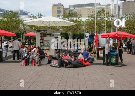 Frankfurt, Germany. 11th October 2018. Visitors enjoy some reading in the outside area of the Frankfurt Book Fair. The 70th Frankfurt Book Fair 2018 is the world largest book fair with over 7,000 exhibitors and over 250,000 expected visitors. It is open from the 10th to the 14th October with the last two days being open to the general public. Stock Photo