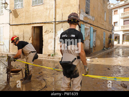 Sant Llorenc Des Cardassar, Spain. 11th Oct, 2018. Members of the emergency services block off a house on a muddy road. Devastating thunderstorms on Mallorca cost the lives of several people on 09.10. Credit: Clara Margais/dpa/Alamy Live News