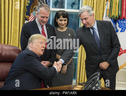 Washington, District of Columbia, USA. 11th Oct, 2018. United States President Donald J. Trump, left, shakes hands with US Senator Sheldon Whitehouse (Democrat of Rhode Island), right, prior to signing S. 3508, the 'Save Our Seas Act of 2018'' in the Oval Office of the White House in Washington, DC on Thursday, October 11, 2018. Looking on are US Senator Dan Sullivan (Republican of Alaska), center left, and Julie Fate, wife of Senator Sullivan, center right Stock Photo