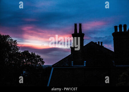 London UK. 12th October 2018. A sunrise with colourful  clouds drifting over  Wimbledon as Storm Callum is expected to reach landfall  bringing rain and 76mph winds to Western parts of the UK Credit: amer ghazzal/Alamy Live News Stock Photo