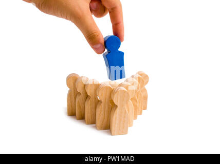 Businessman hand puts the leader in the center of a group of people of the arrow formation on a white background. Teamwork concept, teamwork. Team spi Stock Photo