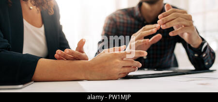 Close up shot focusing on hand gestures of business colleagues during a meeting. Close up of the hand movements of two business people on the table wh Stock Photo