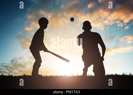 Silhouette Of Boy Playing Baseball With His Father At Sunset Stock Photo