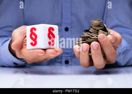 Man's Hand Holding White Cubic Block With Red Paragraph Symbol And Coins Over Desk Stock Photo