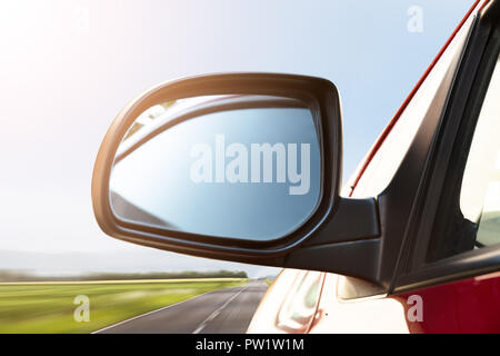Rear View Mirror Of A Car Driving On Street Stock Photo