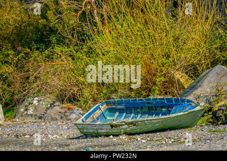 Outdoor view of wooden boat destoyed in the riverside of the lake in Vilupulli building sin the horizont located in Chiloe island, Chile Stock Photo
