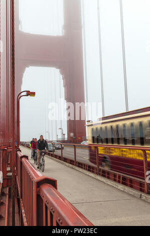 Bikers and a tour bus on the Golden Gate Bridge San Francisco, California, United States, on a late foggy summer morning. Stock Photo